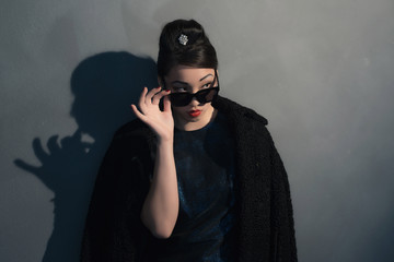 Stylish wealthy asian woman in retro 40s fashion with sunglasses