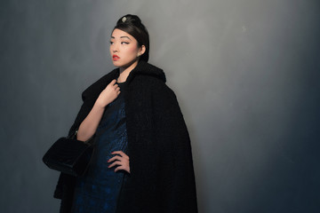 Stylish wealthy asian woman in retro forties fashion with handba