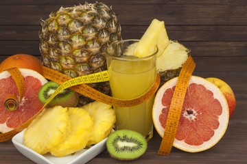 Red grapefruit and fruit for weight loss. Fresh dietary food for athletes. Fruit on a wooden table. Composition with variety of fresh fruits. Balanced diet. Assortment of exotic fruits. 
