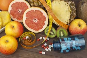 Dietary supplements for weight loss. Red grapefruit and fruit for weight loss. Fresh dietary food for athletes. Fruit on a wooden table.Balanced diet. Assortment of exotic fruits.

