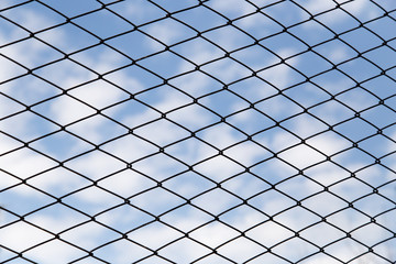 metal fence against the blue sky with clouds