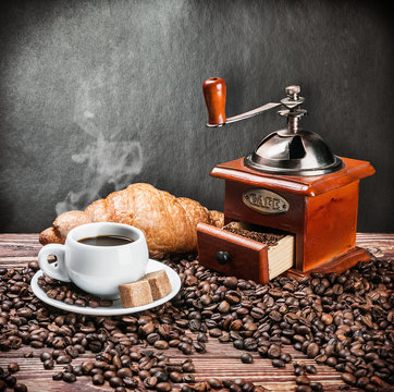 cup of warm coffee and coffee grinder
