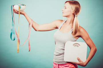Girl with scales measuring tapes. Weight loss.