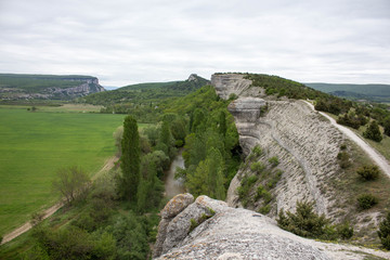 
View from the rocks on the green field and the path .