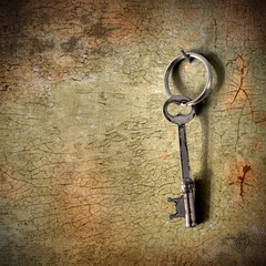 Antique skeleton key hanging on an old wall. 