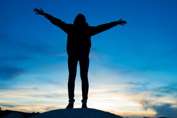 woman jumping against sunset with blue sky