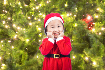 Small Santa Claus girl on bokeh background
