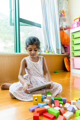 Little girl play with tablet pc at living room