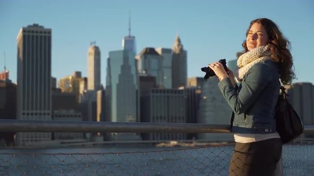 A woman takes pictures of NYC skyline