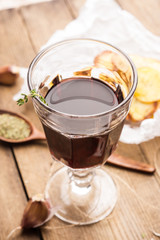 Glass of red wine with homemade potato chips on the background