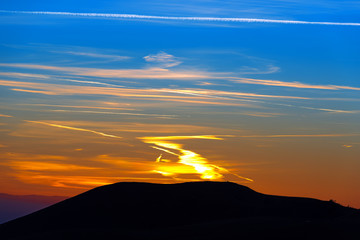 Sunset Over the Mountain / Beautiful sunset with a black mountain silhouette. Italian Alps