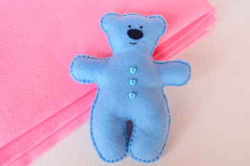 Handmade felt bear - bluу felt bear on white and pink background, hand-stitched toy 