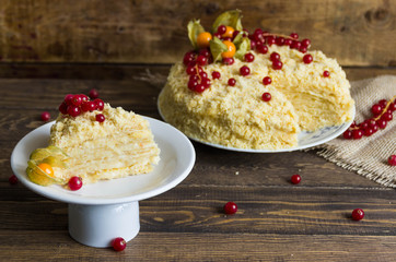 Napoleon cake with berries on wooden background.