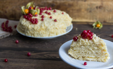 Napoleon cake with berries on wooden background.