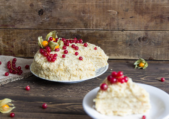 Napoleon cake with berries on wooden background.