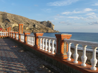 Black sea coast, parapet of embankment closeup, view of rocky  cape Alchak on back plane, Sudak,...
