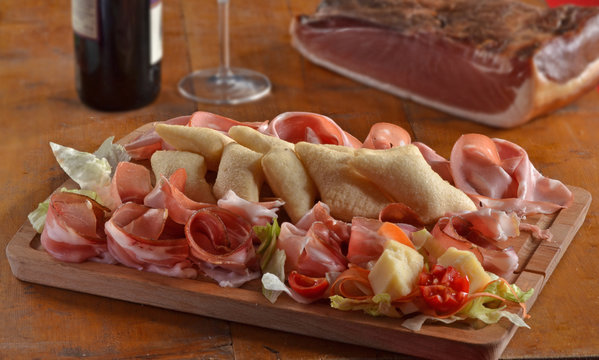 Cortes de jamones crudos n una tabla de madera.