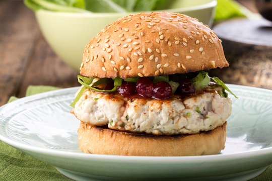 Healthy turkey burger on a bun with cranberry sauce