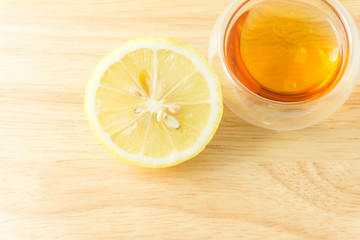 transparent cup of tea and lemon slice on wood background