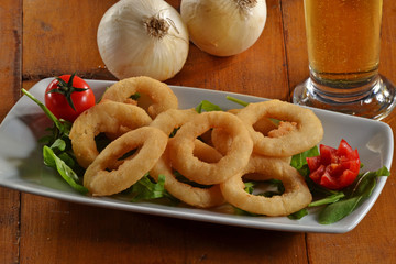 Plato de aros de cebolla frita e ingredientes.