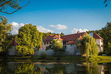 Fototapeta na wymiar Otocec, Slovenia - September 12, 2015. Otocec castle view from the bank of the Krka river.