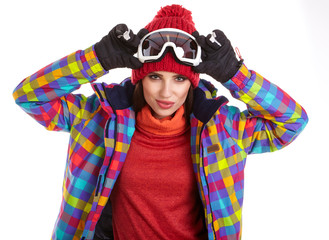 Young smiling woman is posing with ski goggles in studio, isolat
