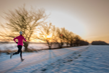 Young woman stretching while running outdoors on a cold winter e