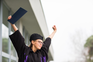 Pretty, young woman celebrating joyfully her graduation