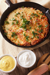 Fried Potato pancakes with herbs close-up in a pan. Vertical
