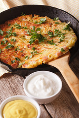Potato rosti with herbs close-up in a pan on the table. vertical 
