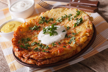 Delicious potato pancakes with sauce close-up on a plate. Horizontal
