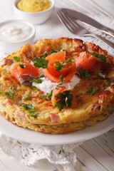 Delicious potato Fritters with salmon on a plate close-up. Vertical 
