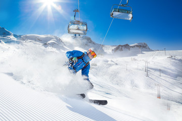 Skier skiing downhill in high mountains