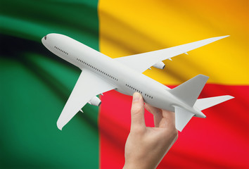 Airplane in hand with flag on background - Benin