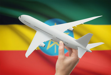Airplane in hand with flag on background - Ethiopia