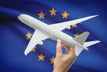 Airplane in hand with flag on background - European Union