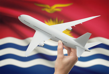 Airplane in hand with flag on background - Kiribati