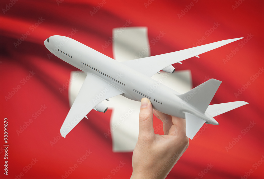 Wall mural Airplane in hand with flag on background - Switzerland