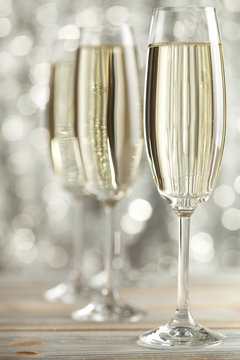 Glasses of champagne on silver background