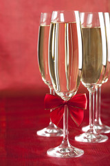 Glasses of champagne on red background