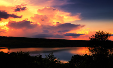 Fototapeta na wymiar Dramatic sunset over lake