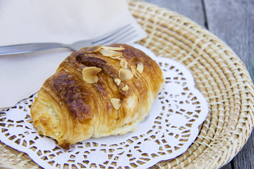 Almond croissant isolated on wooden dish