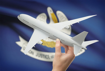 Airplane in hand with US state flag on background - Louisiana