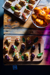 Wooden tray of appetizers on pallet coffee table at banquet.