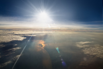 sun and clouds from an airplane window