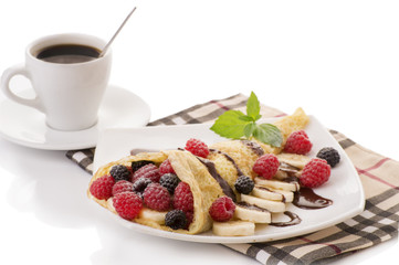Cup of coffee and pancakes with berries