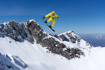 Flying snowboarder on mountains. Extreme sport.