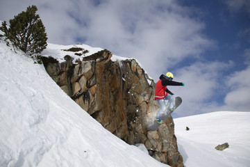 Flying snowboarder on mountains. Extreme sport.