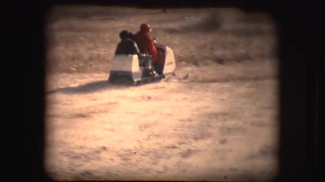 8mm footage of people having fun in winter while using a snowmobile and a sled