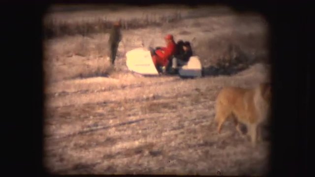 8mm footage of people having fun in winter while using a snowmobile and a sled